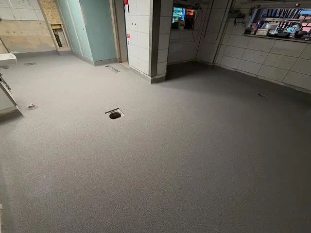 Renovering av fuktskadat golv med Eradur Struktur. Efter – grå beläggning och epoxihålkäl.
