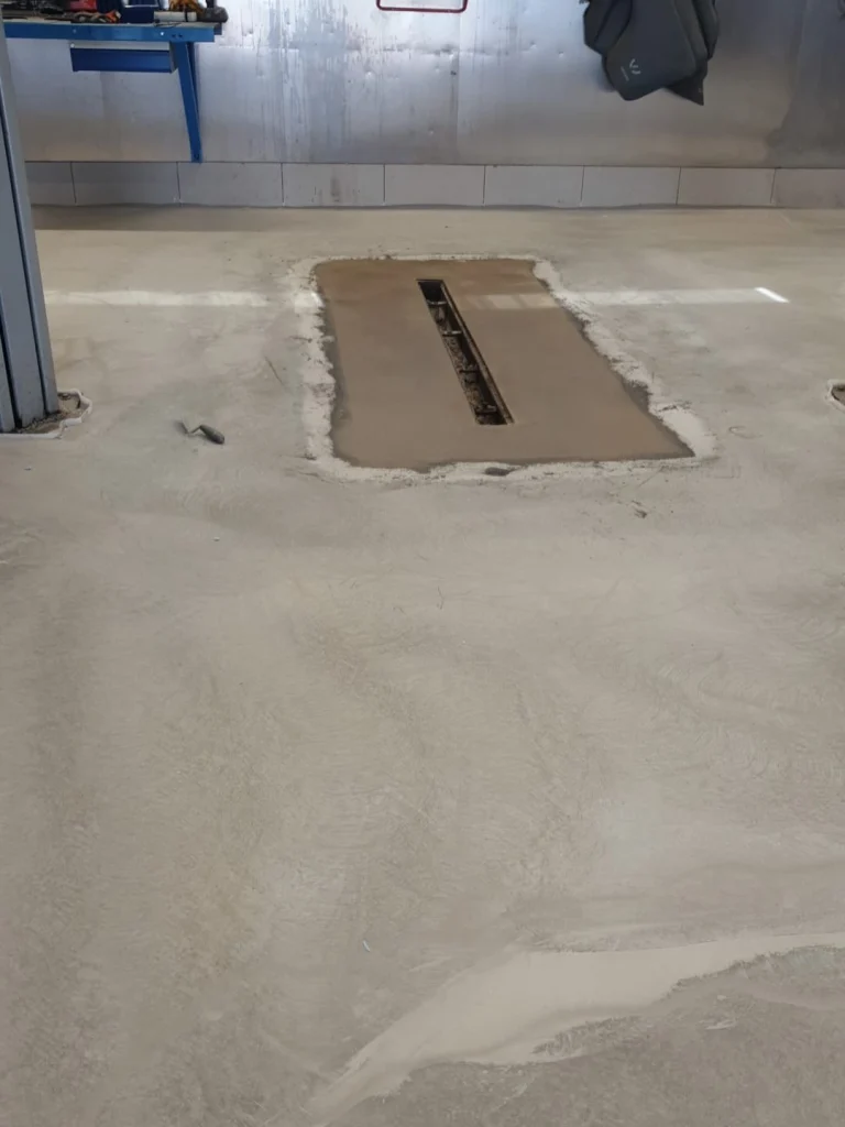 210 m² verkstadsgolv hos Volkswagen Värmdö. Underarbete – avjämnad yta före den färdiga beläggningen.
